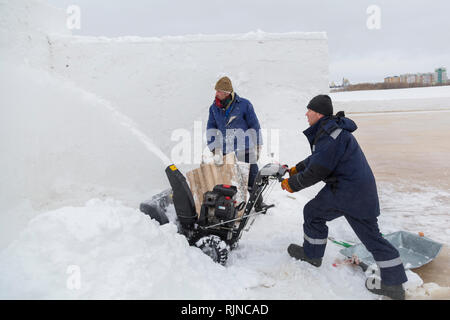 Arbeitnehmer beseitigt Schnee in einem Blizzard mit einem Schneepflug Stockfoto