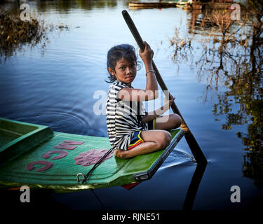 Tonlé Sap See, Kambodscha. 17. Dezember, 2018. Ein Mädchen, das Paddel ihr Boot mit einem einzigen Ruder. Foto: Bryan Watt Stockfoto