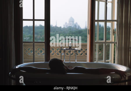 Bildunterschrift: Agra, Rajasthan, Indien - Apr 2003. Ein Gast ist Entspannung in einer Badewanne mit Blick auf den Taj Mahal, in einem der Spa Suiten im Banyan Tree s Stockfoto