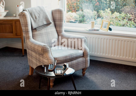 Leeren Wohnzimmer mit einem Sessel und einem Blut-glukose-Prüfung kit auf einen Tisch. Stockfoto