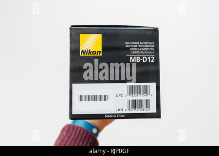 PARIS, Frankreich - Feb 5, 2018: Fotograf Hand gegen den weißen Hintergrund auf ein Feld mit einem Nikon MB-D12 Kamera Grip für die Nikon D810 D800 professionelle DSLR-Kamera Seitenansicht Stockfoto