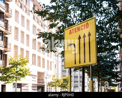 Schuss von unten der gelben Bus station Zeichen, die die Aufmerksamkeit auf mögliche Bewegungen mit Pfeilen, Barcelona Stockfoto