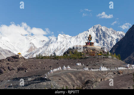 Statue von Jampa (Maitreya) Buddha und viele Chörten in der Nähe von diskit Gompa mit hohen Bergen im Hintergrund, Nubra Valley, Ladakh, Indien Stockfoto