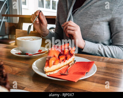 Französische Frau, die köstliche Erdbeere Dessert mit Tasse Kaffee in der Cafeteria Stockfoto