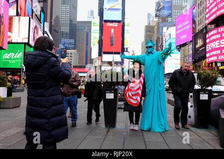 Ein Tourist in ihr Foto mit einem Mann wie die Freiheitsstatue, den Times Square New York City.New York USA gekleidet getroffen. Stockfoto