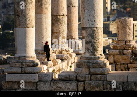 AMMAN - Jordanien - 12. Januar 2019. Ein Mädchen posieren für ein Foto vor einem herrlichen Spalten in der Zitadelle von Amman, Jordanien. Die Zitadelle von Amman Stockfoto