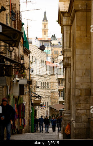 Einige Menschen zu Fuß durch die Straßen der Altstadt von Jerusalem mit Ständen und Geschäfte mit Souvenirs und Lebensmittel. Stockfoto