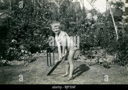 Junge Junge, vier Jahre alt, Kricket spielen in suburban Family Garden, 1938 Stockfoto