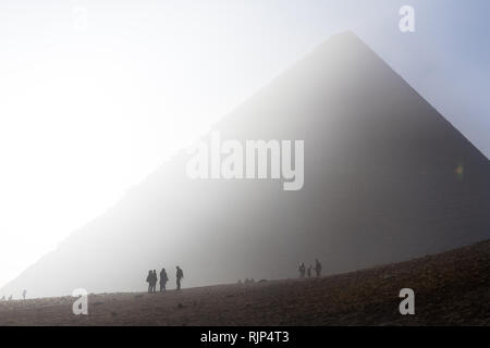 Sonnenaufgang und frühen Besucher vor der Großen Pyramide von Gizeh (Pyramide des Cheops) in Gizeh in der Nähe von Kairo, Ägypten. Stockfoto