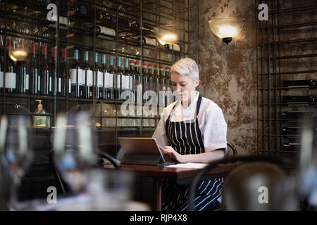 Köchin arbeiten an digitalen Tablet im Restaurant Stockfoto