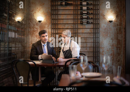 Koch und Restaurantbesitzer im Gespräch mit Finanzberater Investor Stockfoto