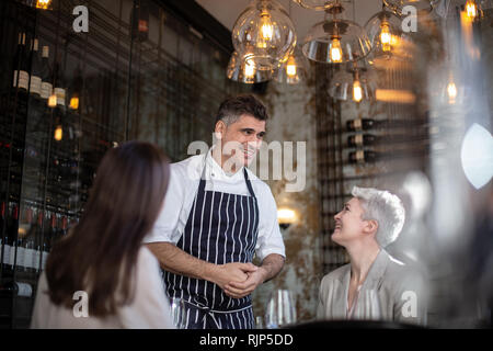 Koch Kunden begrüßt in seinem Restaurant Stockfoto