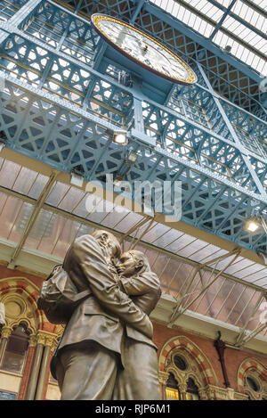 Statue des Umfassens Paar bekannt als Treffpunkt von Paul Tag Passagiere begrüsst bei Ankunft auf dem Londoner Bahnhof St. Pancras, England. Stockfoto