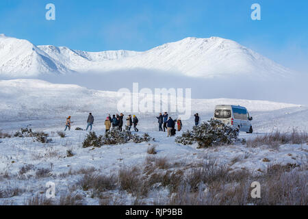 Besucher genießen die Winterlandschaft auf dem Kleinbus tour. Loch Tulla Viewpoint, A82 Road nähern Rannoch Moor, Schottland. Stockfoto