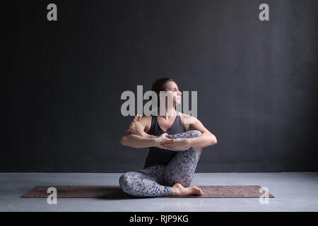 Womanl, Yoga Übung auf dem Boden, Nadel Hüft stretch Tot oder liegende Taube Körperhaltung darstellen, Ausruhen nach der Praxis. Volle Länge Stockfoto