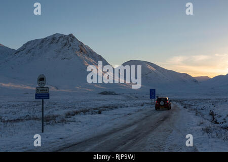 Auto auf der Glen Etive Straße während der schwierigen winterlichen Fahrbedingungen. Am späten Nachmittag, Glen Etive, Highland, Schottland Stockfoto