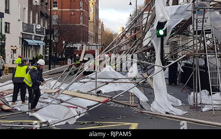 Handwerker ordentlich gefallenen Gerüst an der Kreuzung von Pont Street und Chesham Place in Chelsea, West London, nach Böen nähert sich 80 mph England und Wales mit Wetterwarnungen für weitere starke Winde in Kraft für das Wochenende zu kommen. Stockfoto