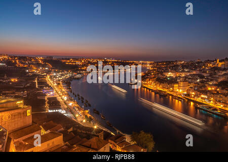 Ansicht der Stadt von Porto in Portugal von der Brücke Dom Luis in der Nacht mit dem Boot auf dem Fluss Stockfoto