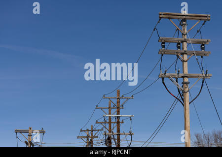 Stromnetz, Reihe von Strommasten und Hochspannungsleitungen vor blauem Himmel in South Dakota, USA Stockfoto