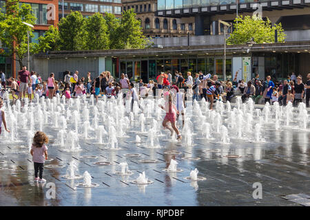 Kinder im Wasser Brunnen in Piccadilly, Manchester spielen an einem warmen Tag im Sommer. Stockfoto