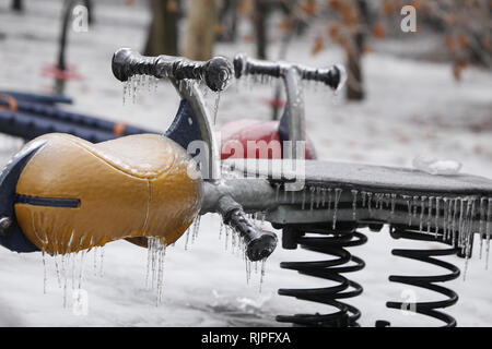 Gefrorene Kinderspielplatz nach einem Regen wetter Phänomen Stockfoto