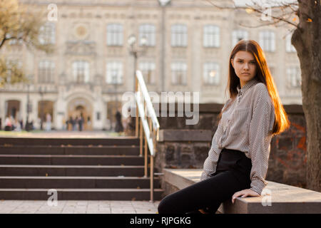 Ein Student sitzt in der Nähe der Stufen der Universität Stockfoto