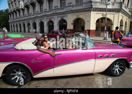 Touristen, die einen kühlen Taxifahrt in einem restaurierten 1950er American Classic Auto auf den Straßen von Havanna Vieja Kuba Stockfoto