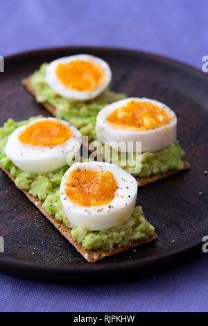 Roggensauerteig frische Sandwiches mit Guacamole, gekochte Eier. Auf einem dunklen Holz- Teller serviert, hohe Auflösung Stockfoto