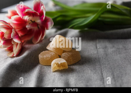 Marmelade und Tulpen auf grauem Hintergrund Stockfoto