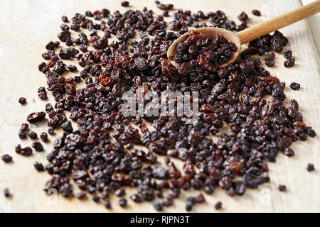 Korinthen und Rosinen auf Tabelle mit Holzlöffel, Ansicht von oben Stockfoto