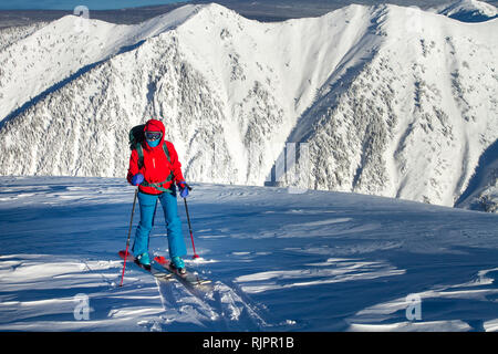 Mädchen macht Skibergsteigen allein in Richtung der Mountain Pass in eine schöne Strecke mit Seehundsfell Stockfoto