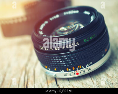 Schließen Sie herauf Foto der alten Kamera über Holz- Tabelle. Bild ist retro gefiltert. selektive Fokus, lens flare Stockfoto