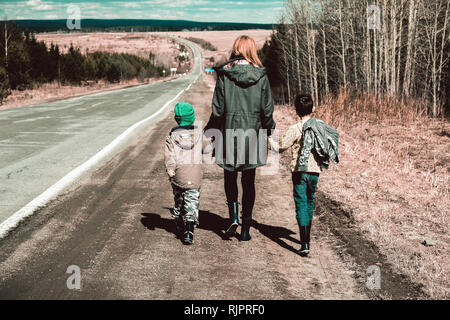 Mutter und Söhne zu Fuß entlang der Strecke von entfernten Straße, Ural, Sverdlovsk, Russland Stockfoto