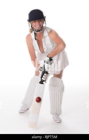 Frau cricketer in einem weißen Kleid mit offenbart ein Schutzhelm, shin Pads, Schläger und Ball. Stockfoto