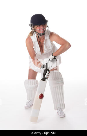 Frau cricketer in einem weißen Kleid mit offenbart ein Schutzhelm, shin Pads, Schläger und Ball. Stockfoto