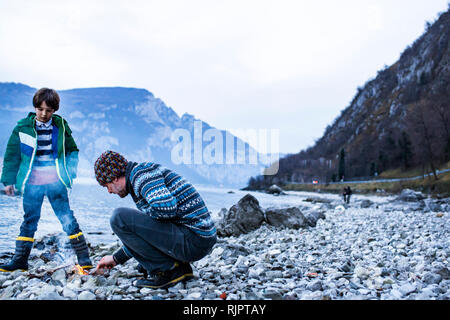 Vater und Sohn ab Lagerfeuer, Onno, Lombardei, Italien Stockfoto