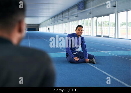 Läufer sitzen auf Indoor-laufbahn Stockfoto