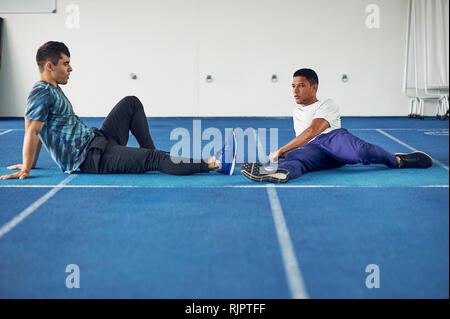 Läufer sitzen auf Indoor-laufbahn Stockfoto