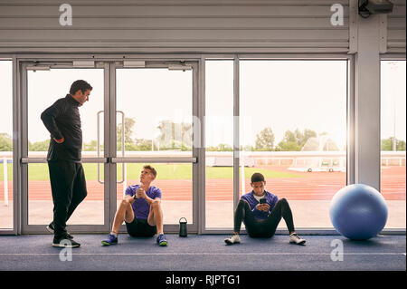 Trainer und Läufer sprechen in Indoor-laufbahn Stockfoto