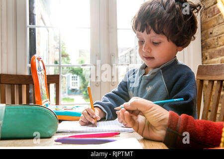 Mutter und Sohn schreiben im Notebook Stockfoto