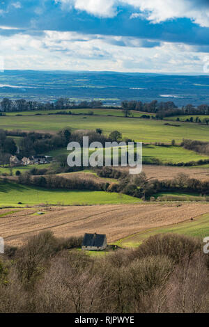 Blick vom Gipfel des Painswick Leuchtfeuer in den Cotswolds, Goucestershire, UK. Stehend auf dem Hügel fort, über Felder und Hütten mit Blick auf die Stockfoto