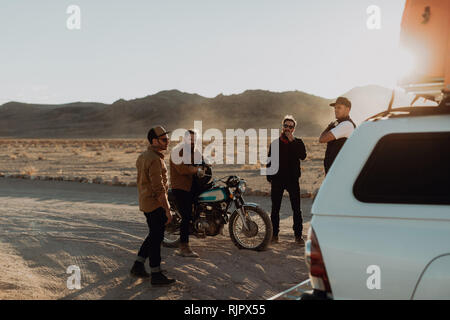 Motorradfahrer Freunde unter Pause neben Geländewagen, Trona Pinnacles, Kalifornien, USA Stockfoto