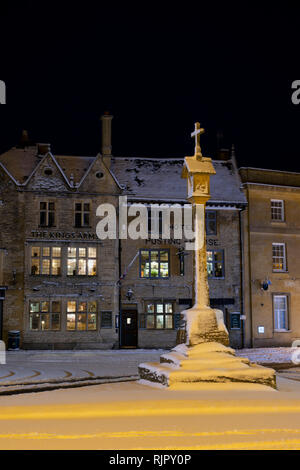 Der Marktplatz Kreuz vor der Kings Arms Pub vor Sonnenaufgang im Winter Schnee. Verstauen auf der Wold, Cotswolds, Gloucestershire, England Stockfoto