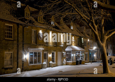 Die alten Bestände Inn vor Sonnenaufgang im Winter Schnee. Verstauen auf der Wold, Cotswolds, Gloucestershire, England Stockfoto