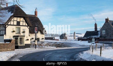 Das Red Lion Pub im Schnee in Avebury, Wiltshire, England. Panoramablick Stockfoto