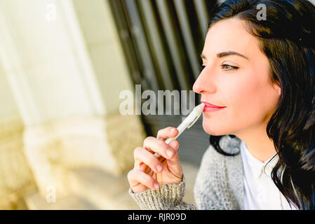 Reife Frau mit dunklen Haaren Denken besorgt sich Notizen mit einem Stift, kopieren. Stockfoto