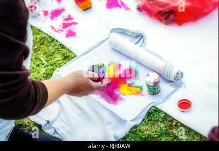 Erstellen Sie Ihre eigenen T-shirt Workshop. Junge Frau Hand malen auf t shirt Stockfoto