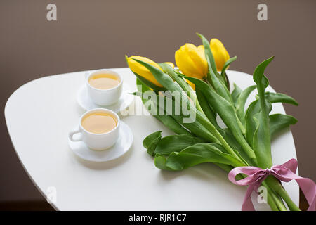 Schöne gelbe Tulpen auf den Tisch, zwei Tassen Tee Grün Stockfoto