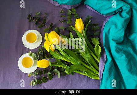 Gelbe Tulpen und zwei Tassen Kaffee im Bett, morgen Stockfoto