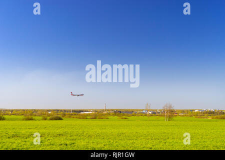 Passagierflugzeug landet auf Start- und Landebahn am Flughafen Pulkowo. Jets am Himmel über dem Feld. Passagier- und Frachtverkehr auf den großen internationalen Flughafen von St. Petersburg, Russland Stockfoto